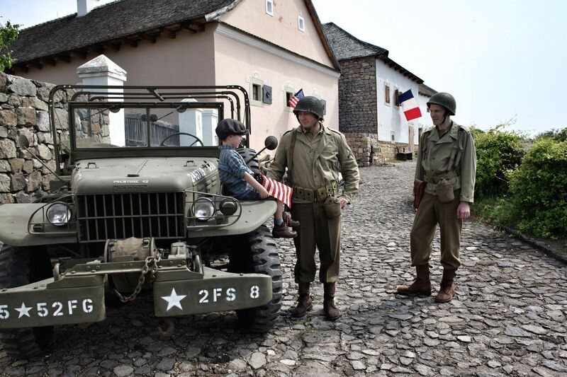 Soldados aliados junto a un jeep con banderas de Francia y Estados Unidos